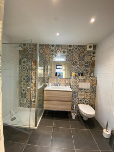 a bathroom with a shower and a sink and a toilet at Guesthouse The White House - gehele huisje in Klaaswaal