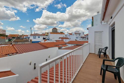a balcony with chairs and a view of the city at Ginjinha in Setúbal