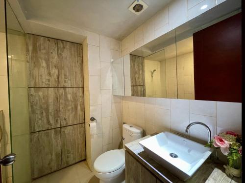 ein Badezimmer mit einem Waschbecken, einem WC und einem Spiegel in der Unterkunft Lavenderbnb Room 5 at Mataram City in Yogyakarta