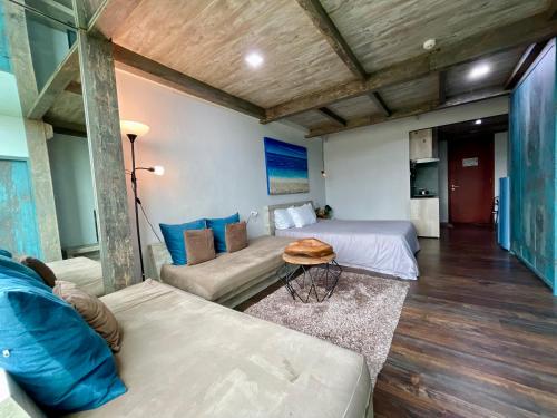 Zimmer mit 2 Betten, einem Sofa und einem Tisch in der Unterkunft Lavenderbnb Room 5 at Mataram City in Yogyakarta