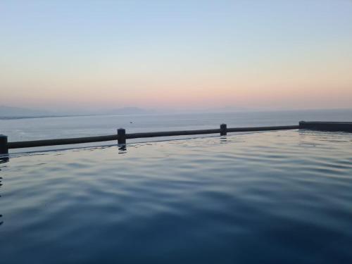 a swimming pool with the ocean in the background at In Costa Relais & Luxury Suites in Vietri sul Mare
