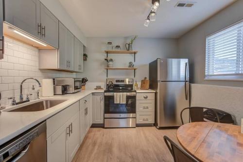 a kitchen with a table and a stainless steel refrigerator at Romantic Getaway Base of Mountains Parks & Trails in Colorado Springs