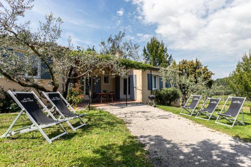 a row of lawn chairs in front of a house at Clos Saint-Michel Resort & Spa in Malaucène