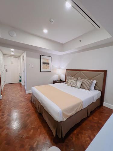 a bedroom with a large bed in a room at Olympia Makati Studio former Somerset Olympia Makati in Manila