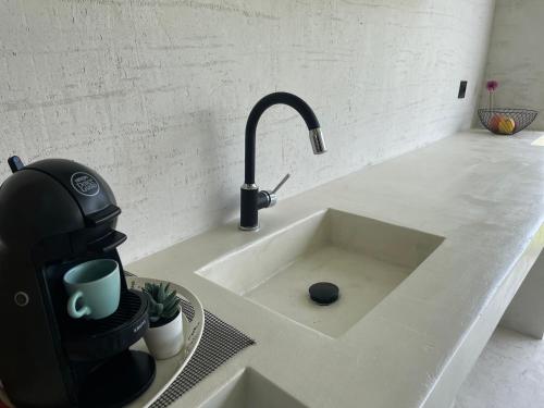 a kitchen counter with a sink with a coffee maker at Krum's Little Secret Villa in Vourvourou
