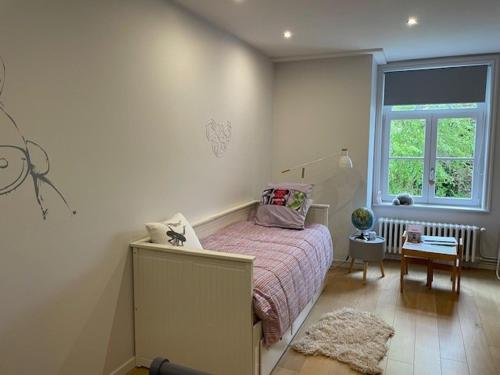 a small bedroom with a bed and a window at Proche Lille Logement dans Propriété de standing in La Chapelle dʼArmentières