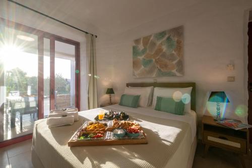 Una habitación de hotel con una cama con una bandeja de comida. en Abeloessa Methonian Hospitality en Methoni
