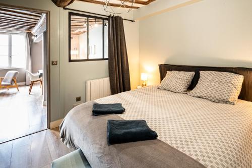 a bedroom with a large bed with two pillows on it at Cosy loft - plein centre d'Honfleur in Honfleur