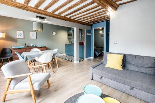 a living room with a couch and a table at Cosy loft - plein centre d'Honfleur in Honfleur