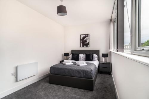 a bedroom with a bed and a large window at Modern 1 Bed Apartment in Central Wrexham in Wrexham