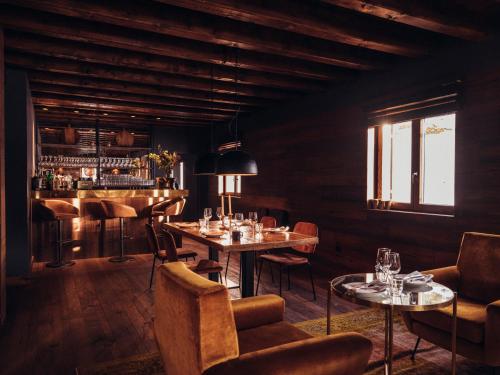 卡尼略的住宿－L´Ovella Negra Mountain Lodge，一间带桌椅的餐厅和一间酒吧