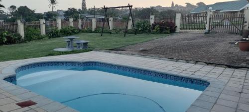 una piccola piscina in un cortile con parco giochi di SUNSET REST BEACH VILLA a Margate
