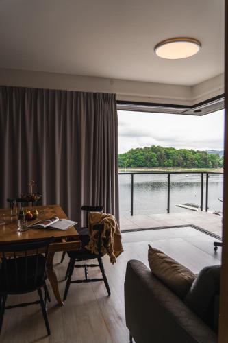 a living room with a table and a large window at NOI Resort SPA - woda i las in Tęgoborze