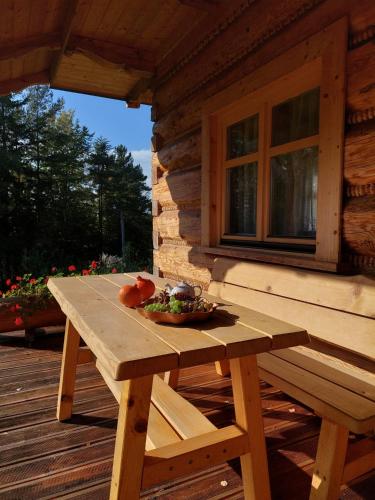 a wooden picnic table on the porch of a cabin at Domek u Heli in Limanowa