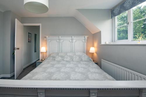 a large bed in a room with two lamps at Stable Cottage in Ilminster