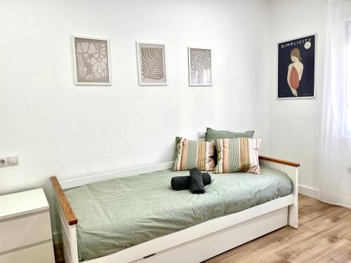 un letto in una camera con pareti bianche di Recién reformado, céntrico, tranquilo y luminoso a Oviedo
