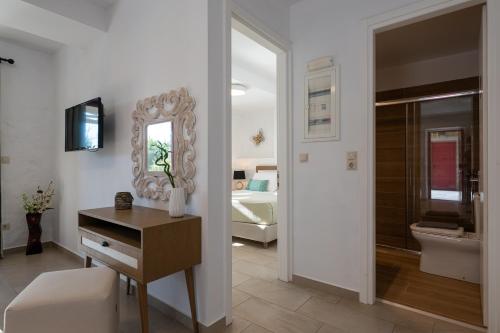 a bathroom with a mirror and a bedroom with a bed at Abeloessa Methonian Hospitality in Methoni