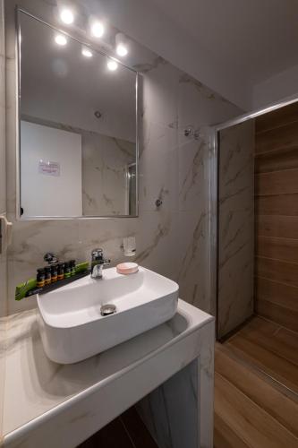 a bathroom with a sink and a mirror and a shower at Abeloessa Methonian Hospitality in Methoni