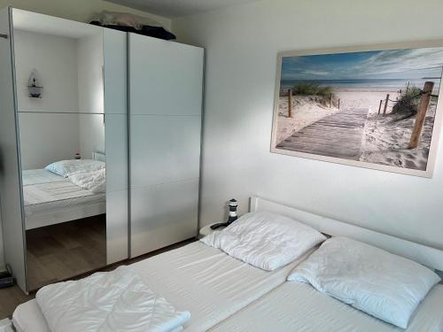 a bedroom with two beds and a picture of a beach at Tamaris Resort in Graal-Müritz