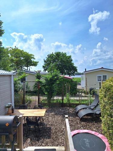 a backyard with a picnic table and a playground at EnJoy Meer und See Ferienhaus -In Lauwersoog- 1-6 Pers- 3 Schlafzimmer in Lauwersoog