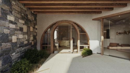 une entrée voûtée vers un bâtiment avec un mur en pierre dans l'établissement Elounda Stories Boutique Hotel, à Elounda