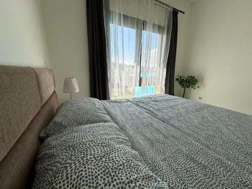 a bedroom with a large bed and a window at Marassi Luxurious 2 bedrooms Direct Lagoon -Steps to the Beach ,El Alamein hotel& Marina in El Alamein