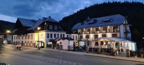 a group of buildings on a city street at night at Hotel Kolorowa in Karpacz