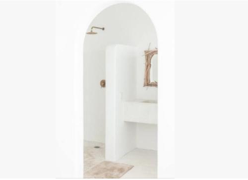 a bathroom with white walls and a mirror at Punta Mayia in Brisas de Zicatela