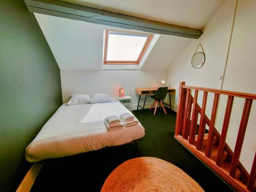 - une chambre avec un lit et une table avec une fenêtre dans l'établissement Rêves & Bois - Séjour à Auxerre, à Auxerre