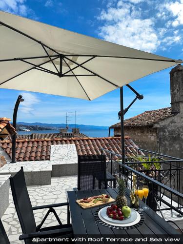 a table with a plate of food and an umbrella at Villa Volos , free private parking in Opatija
