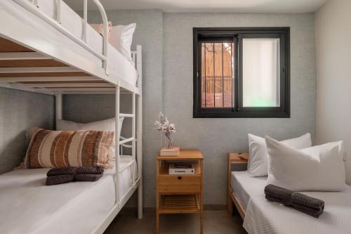 1 dormitorio con 2 literas y ventana en Pluto apartments, en Jerusalén