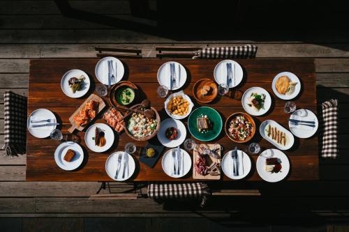 a wooden table with plates of food on it at L´Ovella Negra Mountain Lodge in Canillo