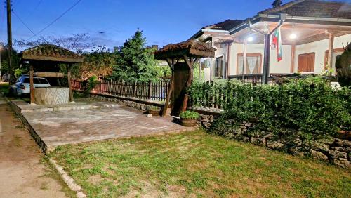 a backyard with a gazebo and a house at Къщата с Кладенеца - с. Генерал Кантарджиево in General-Kantardzhievo
