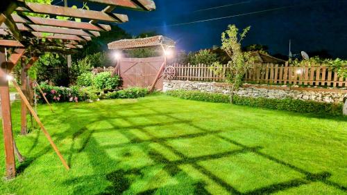 a garden at night with a pergola at Къщата с Кладенеца - с. Генерал Кантарджиево in General-Kantardzhievo