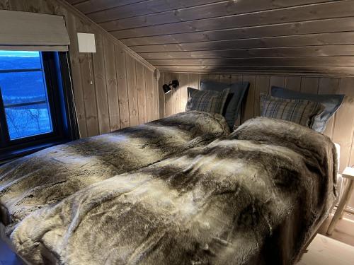 a large bed in a room with a window at Ny flott høyfjellshytte på Geilo! 8 min til Kikut in Geilo