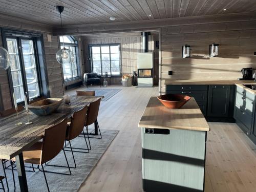 a large kitchen with a table and some chairs at Ny flott høyfjellshytte på Geilo! 8 min til Kikut in Geilo