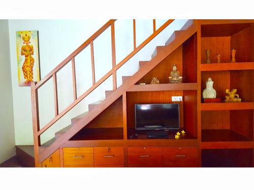 a living room with a staircase with a tv at Juada Garden in Seminyak