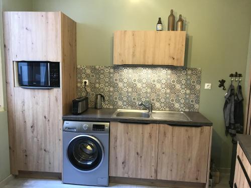 una cocina con fregadero y lavadora en Maison familiale proche Nausicaa, en Boulogne-sur-Mer