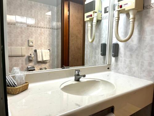 a bathroom with a sink and a mirror at Art & Hotel Treviolo in Treviolo
