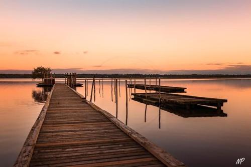 a dock on a body of water at sunset at Appartement en pleine nature in Soustons