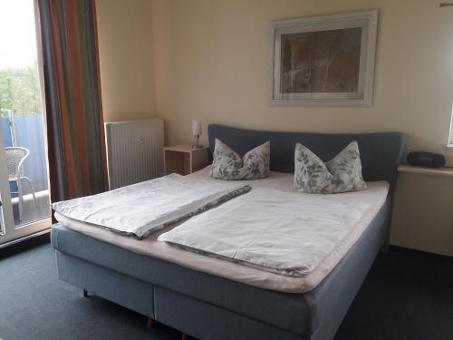 uma cama com duas almofadas num quarto em Herberge 39 em Meissen