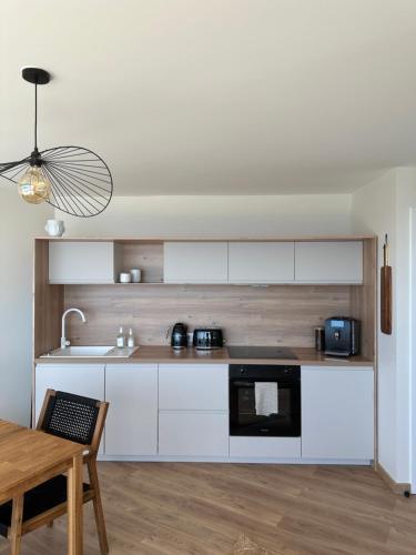 La cuisine est équipée de placards blancs et d'un four micro-ondes noir. dans l'établissement La Tour Somma, à Valras-Plage