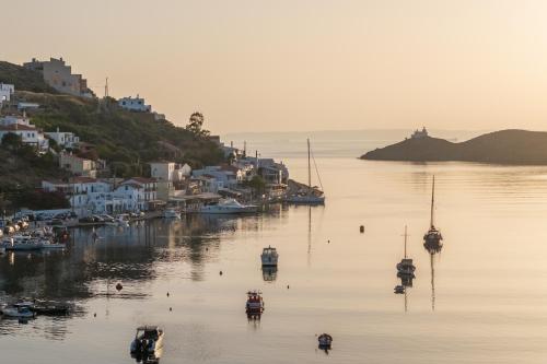 a group of boats in a body of water with houses at oKEAnõs in Vourkarion