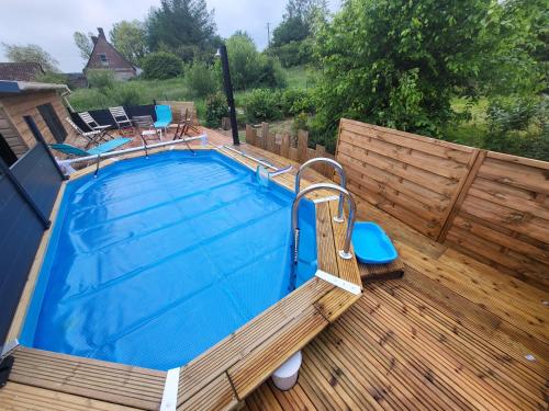 a swimming pool on a wooden deck with a wooden fence at Gîte La Clé de Saint-Jean in Ergny