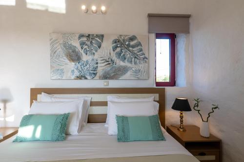 a bedroom with a bed with white and green pillows at Abeloessa Methonian Hospitality in Methoni