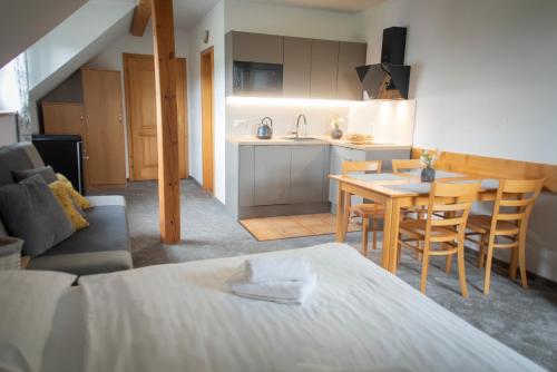a kitchen and a living room with a table and chairs at Penzion Horska Kvilda in Horská Kvilda
