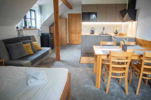 a kitchen and a living room with a table and chairs at Penzion Horska Kvilda in Horská Kvilda