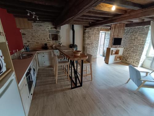 une cuisine avec une table et des chaises dans une pièce dans l'établissement Gîte de la Forêt, à Le Mesnil-Rogues