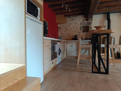 une cuisine avec des murs rouges et du parquet dans l'établissement Gîte de la Forêt, à Le Mesnil-Rogues