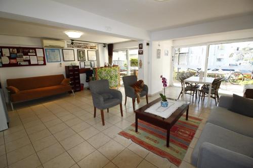 - un salon avec un canapé, une table et des chaises dans l'établissement Bonapart Hotel, à Çeşme